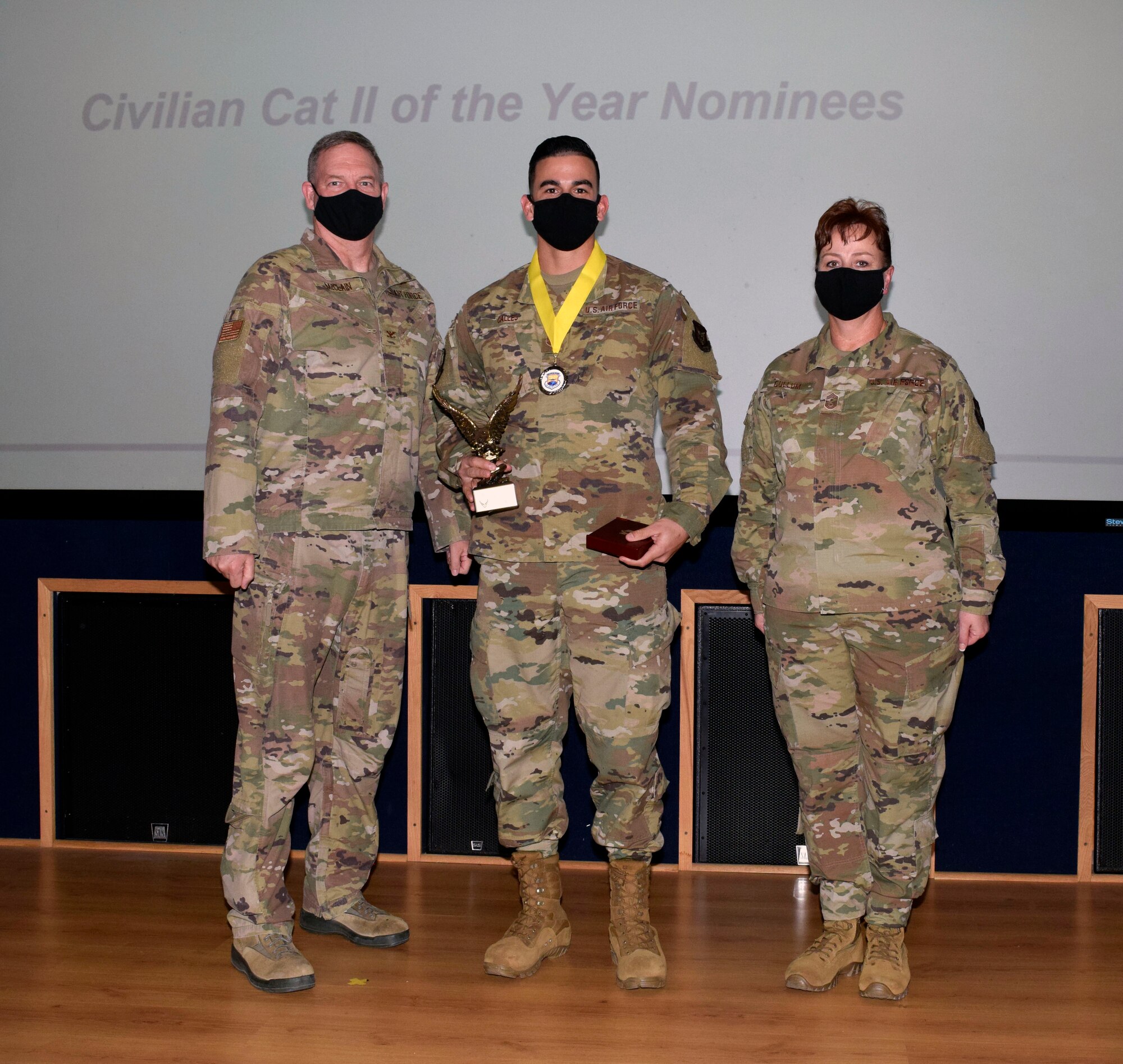Col. Terry W. McClain, 433rd Airlift Wing commander, and Chief Master Sgt. Shana C. Cullum, 433rd AW command chief, stand to the sides of civilian category I winner, Martin R. Calles Jr., 433rd Aircraft Maintenance Squadron, at the wing’s annual award recognition ceremony Jan. 30, 2021 at Joint Base San Antonio-Lackland, Texas. (U.S. Air Force photo by Airman 1st Class Brittany K. Wich)