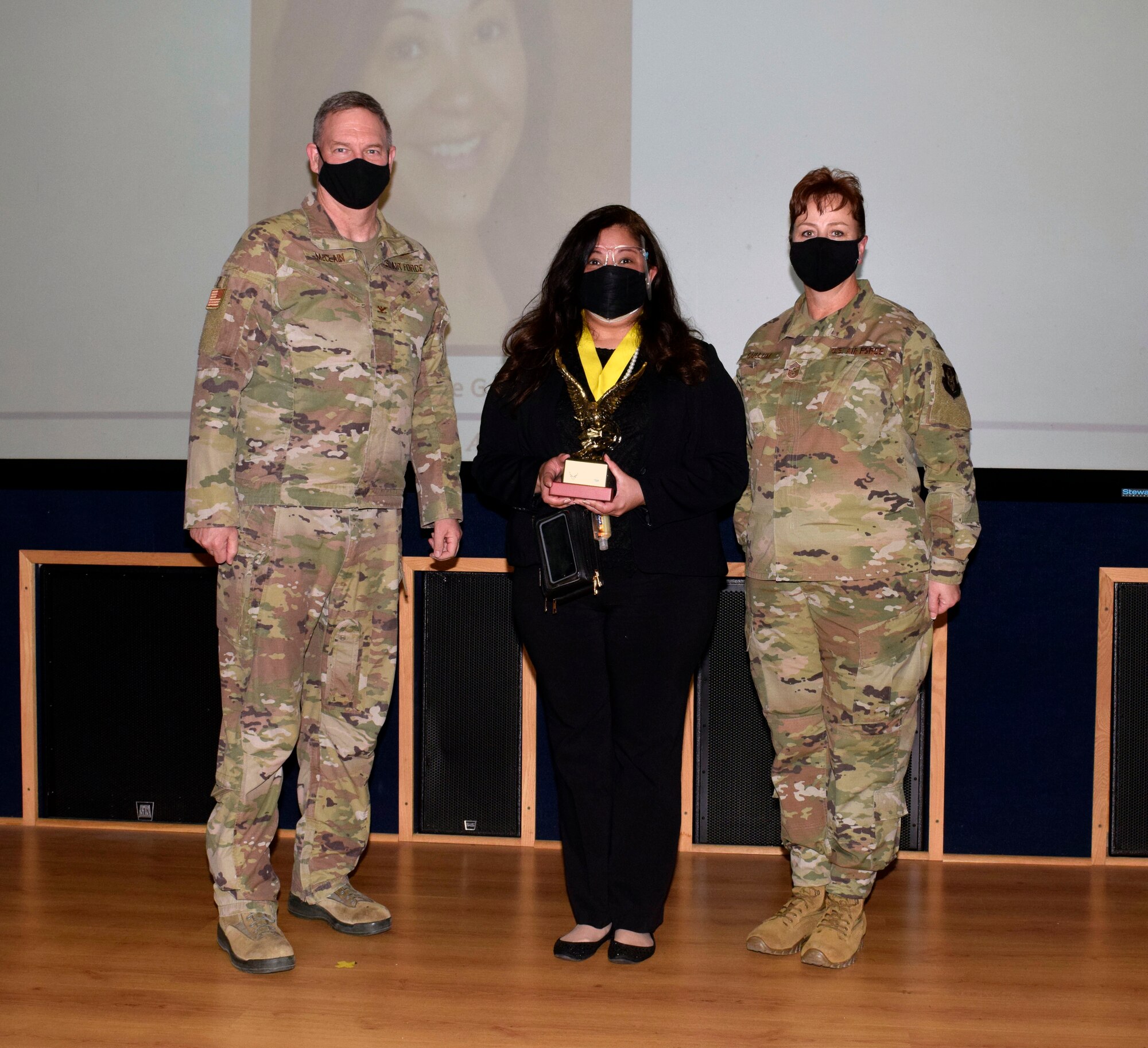Col. Terry W. McClain, 433rd Airlift Wing commander, and Chief Master Sgt. Shana C. Cullum, 433rd AW command chief, stand to the sides of civilian category II winner, Nicole Garcia, 433rd Force Support Squadron, at the wing’s annual award recognition ceremony Jan. 30, 2021 at Joint Base San Antonio-Lackland, Texas. (U.S. Air Force photo by Airman 1st Class Brittany K. Wich)