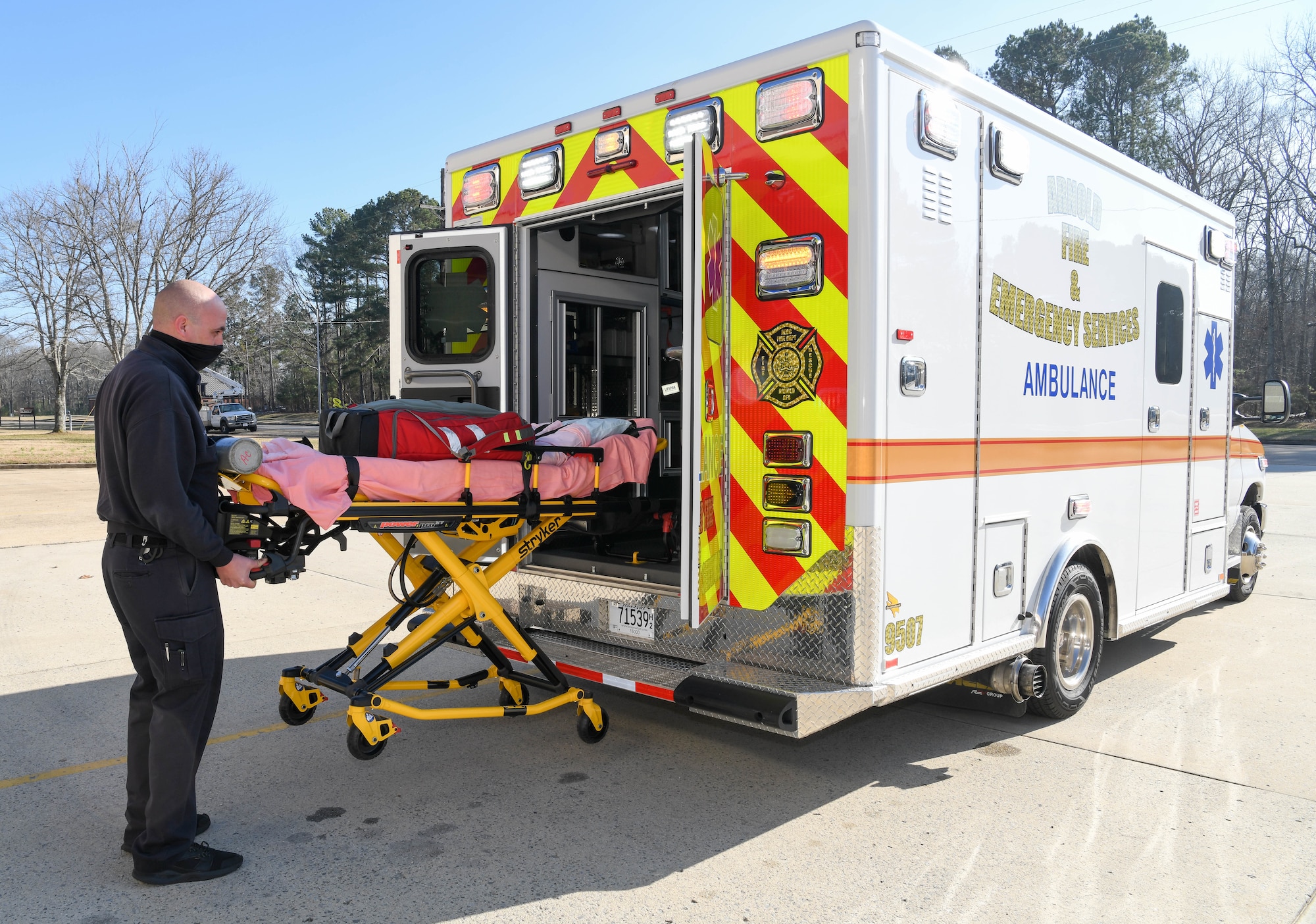 Joey Anderson, a firefighter/paramedic for Arnold Air Force Base Fire and Emergency Services, demonstrates the cot with power-assisted loading system on the newly-acquired ambulance Jan. 12, 2021, Arnold AFB, Tenn. The loading system enhances patient safety and helps prevent back injuries to firefighters. (U.S. Air Force photo by Jill Pickett)