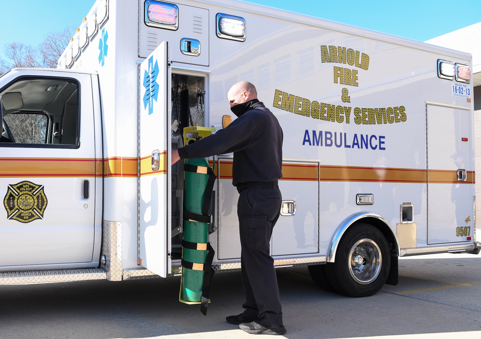 Joey Anderson, a firefighter/paramedic for Arnold Air Force Base Fire and Emergency Services, demonstrates the powered oxygen tank lift on the newly-acquired ambulance Jan. 12, 2021, Arnold AFB, Tenn. The tank is more accessible than on the previous style of ambulance, and the lift increases safety for firefighters. (U.S. Air Force photo by Jill Pickett)