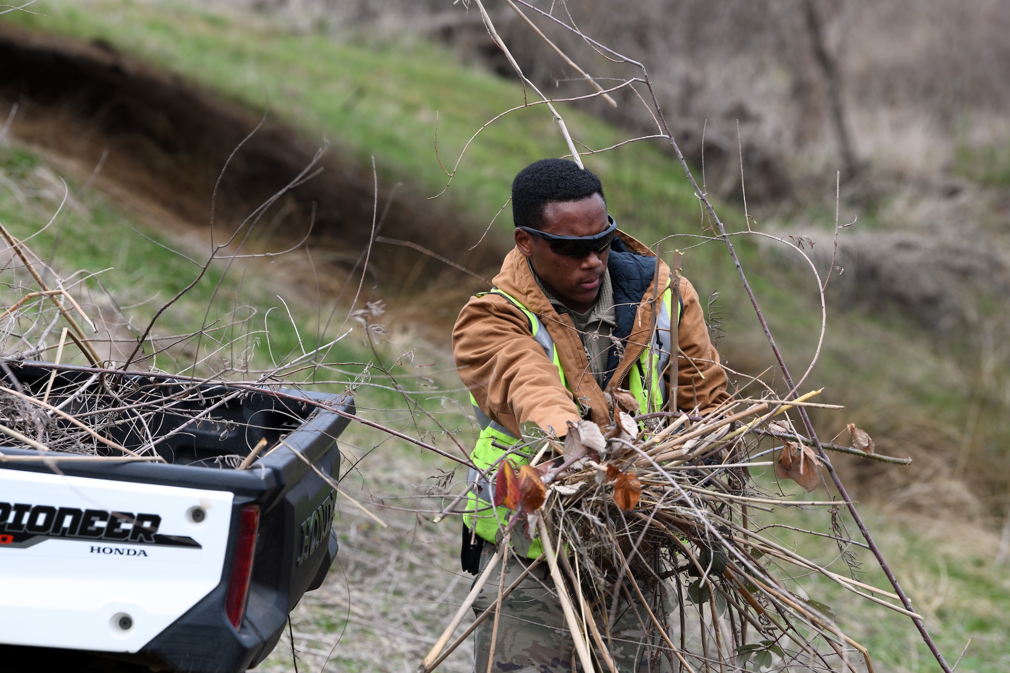 Senior Airman Diante Townsend, 9th Civil Engineering Squadron pavement and construction equipment specialist, loads an all-terrain vehicle with young trees that were cut down, Jan. 8, 2020, at Beale Air Force Base, California. The trees were cut down as a flood prevention effort. (U.S. Air Force photo by Airman 1st Class Luis A. Ruiz-Vazquez)