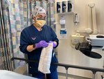 Lt. Cmdr. Jasmyne Irizarry, a perioperative nurse at Naval Hospital Jacksonville, opens a sequential compression device for a patient prior to surgery.