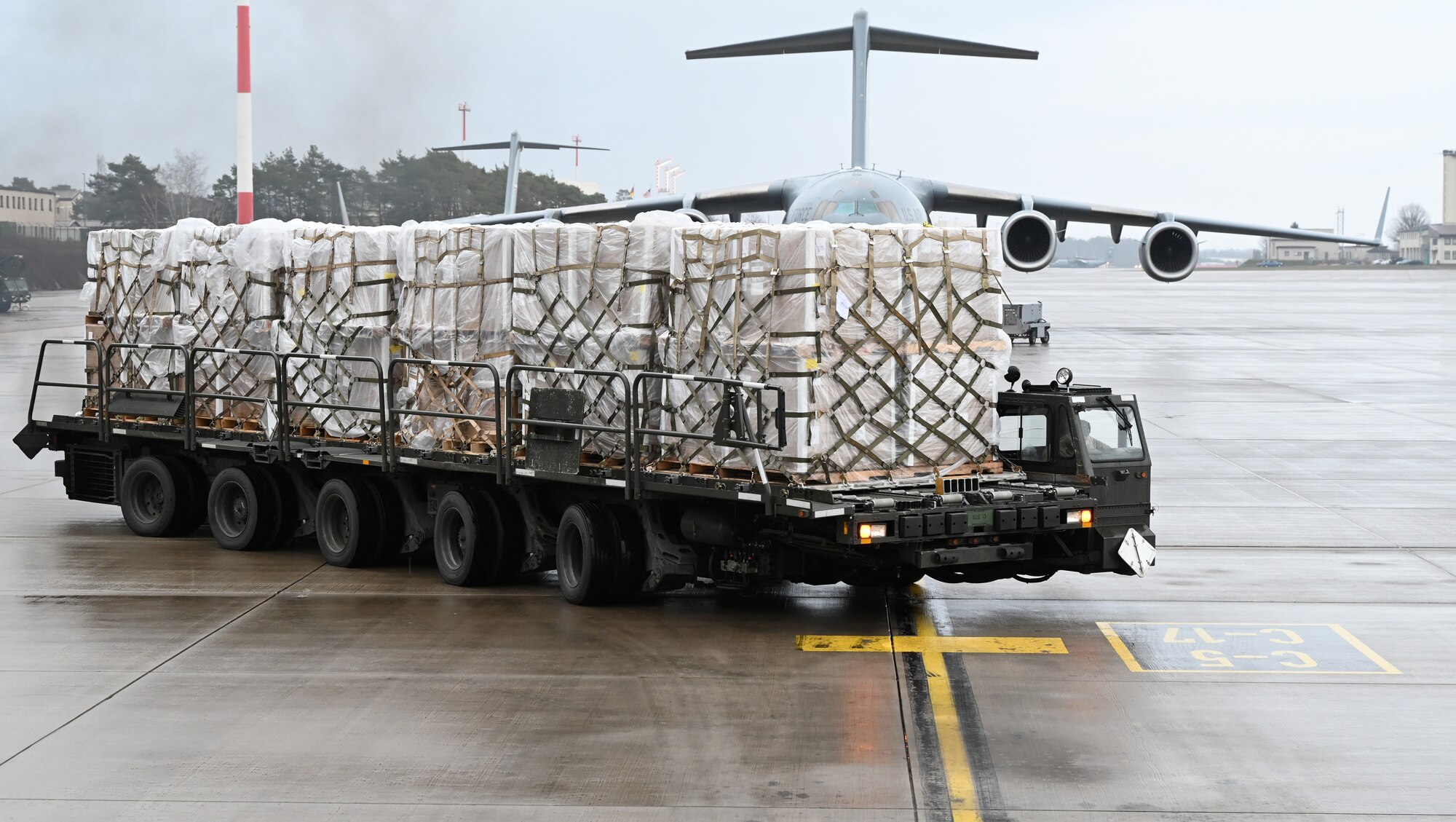 A Tunner aircraft loader transports bundles of masks at Ramstein Air Base, Germany, Feb. 2, 2021. The 721st Aerial Port Squadron Airmen unloaded approximately 15 tons of  masks for U.S. service members across Germany. The squadron plays an important role in the distribution of masks and other COVID-19 protective equipment to help fight COVID-19.. (U.S. Air Force photo by Senior Airman Thomas Karol)