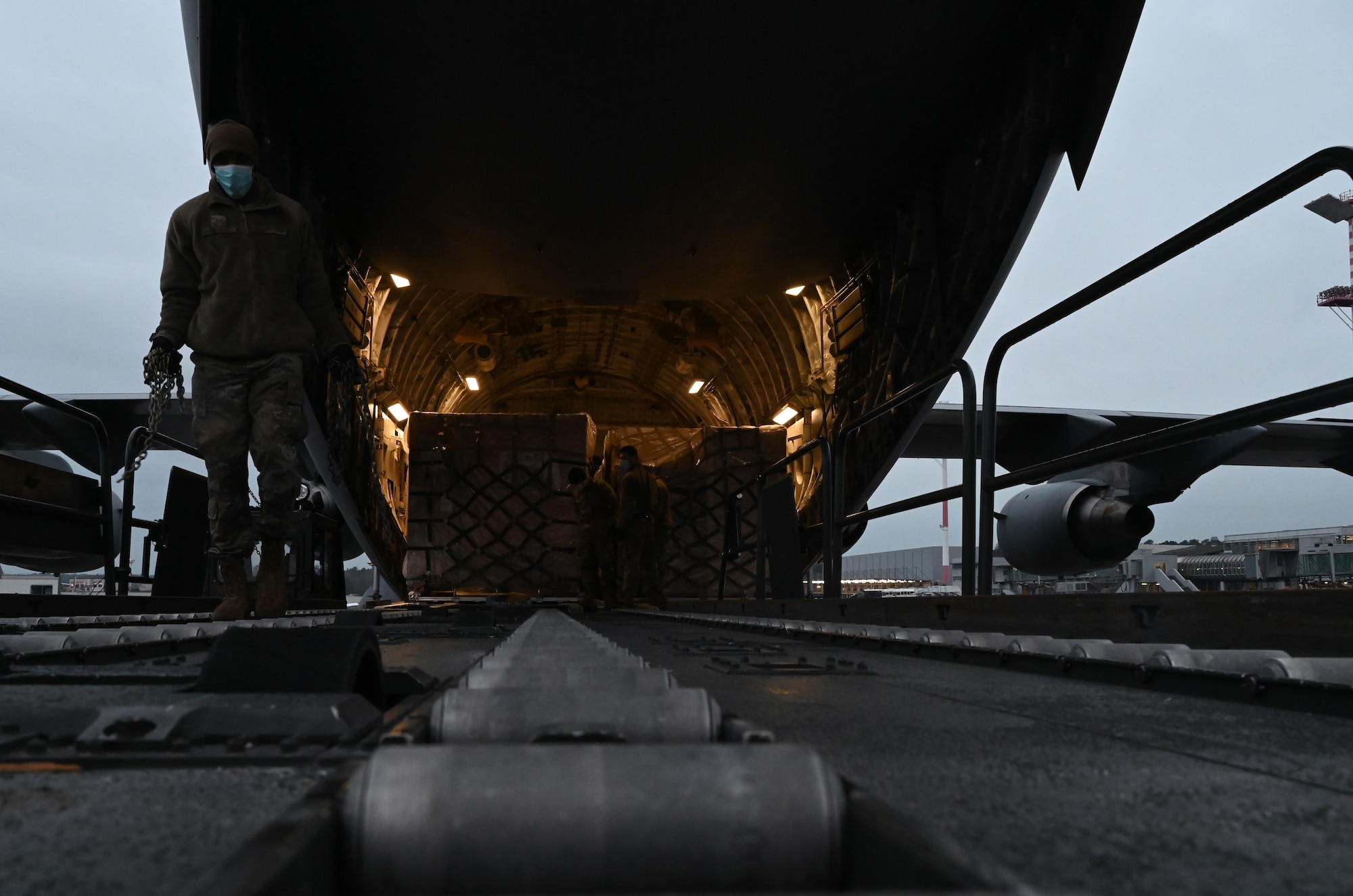 Airmen from the 721st Aerial Port Squadron unload a C-17 Globemaster III at Ramstein Air Base, Germany, Feb. 2, 2021. Ramstein received 15 pallets of masks for distribution to U.S. military bases around Germany. The 721st APS plays an important role in the delivery of masks and other COVID-19 protective equipment. (U.S. Air Force photo by Senior Airman Thomas Karol)