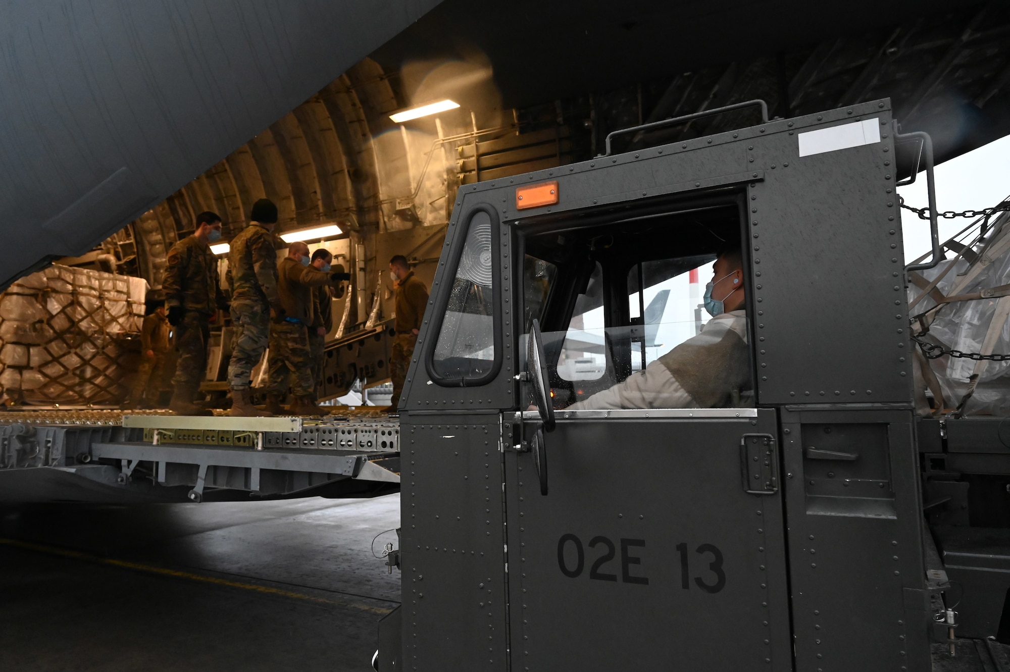 U.S. Air Force Airman 1st Class Kevin Sunti, 721st Aerial Port Squadron ramp services specialist, operates a Tunner aircraft loader at Ramstein Air Base, Germany, Feb. 2, 2021. Approximately 15 tons of masks were delivered to Ramstein by the Defense Logistics Agency. The 721st APS plays an important role in the distribution of masks and other COVID-19 protective equipment. (U.S. Air Force photo by Senior Airman Thomas Karol)