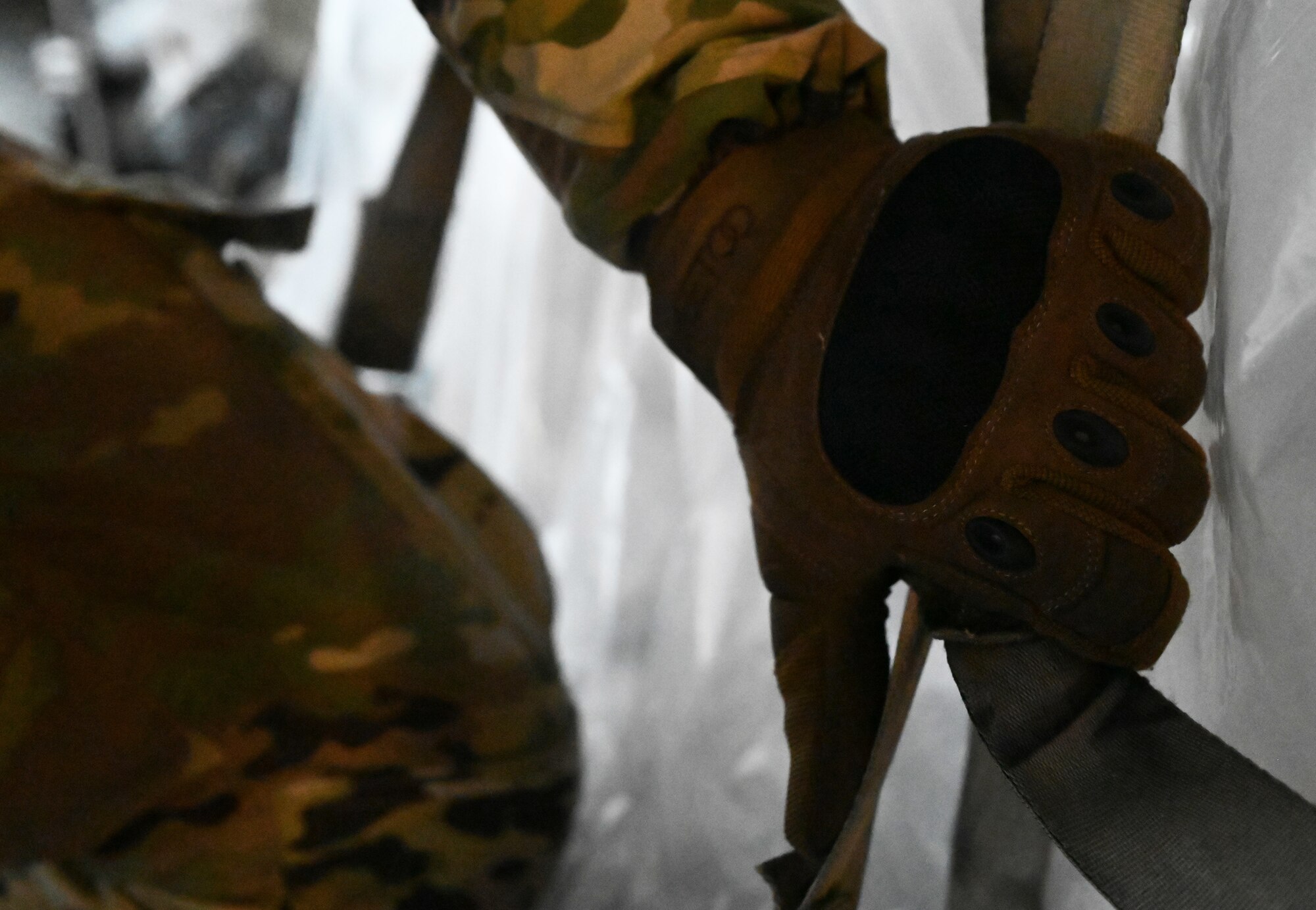 U.S. Air Force Airman David Hanus, 721st Aerial Port Squadron ramp services specialist, checks a strap at Ramstein Air Base, Germany, Feb. 2, 2021. Hanus and other 721st APS Airmen unloaded approximately 400,000 masks for U.S. service members in Germany. The masks, which are more effective than cloth face coverings, help service members remain compliant with host nation regulations and contribute to the joint fight against COVID-19.  The 721st APS plays an important role in the distribution of masks and other COVID-19 protective equipment.. (U.S. Air Force photo by Senior Airman Thomas Karol)