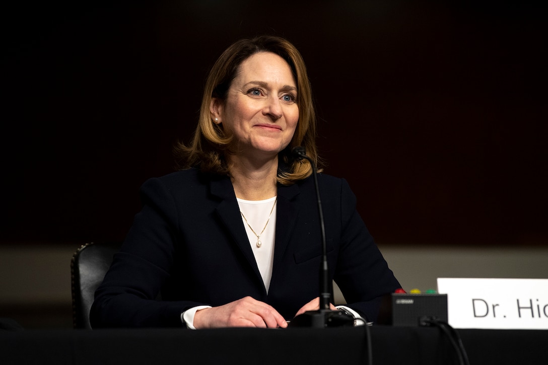 Kathleen H. Hicks smiles while seated at a table.