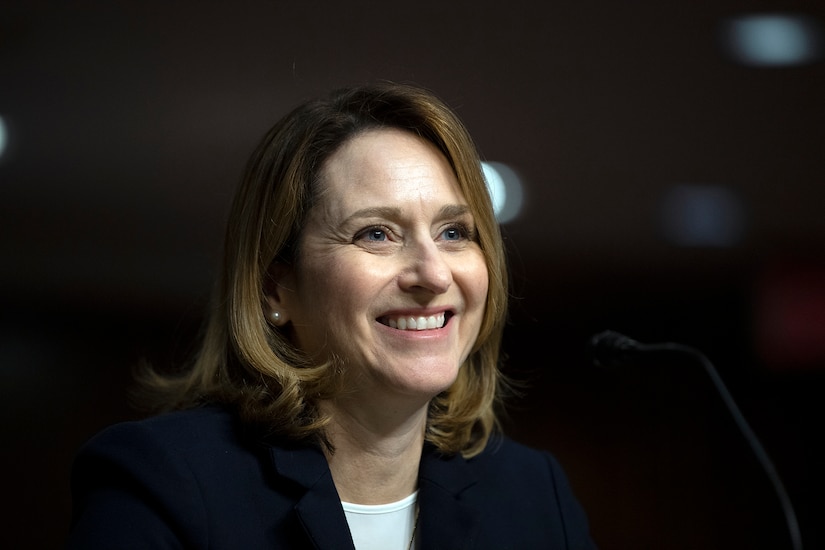 Kathleen H. Hicks smiles while seated at a table.