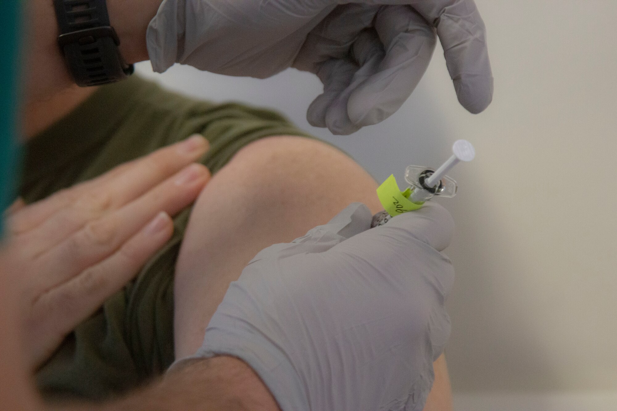 Image of a Marine receiving a vaccine in the arm.