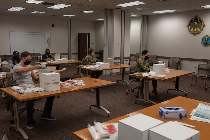 Photo of volunteers putting together COVID-19 test kits.