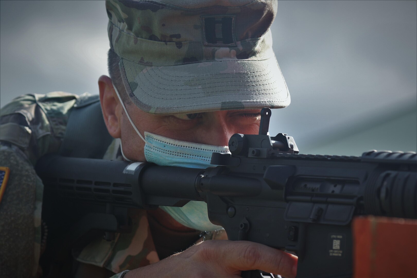 A man in uniform aims a weapon.