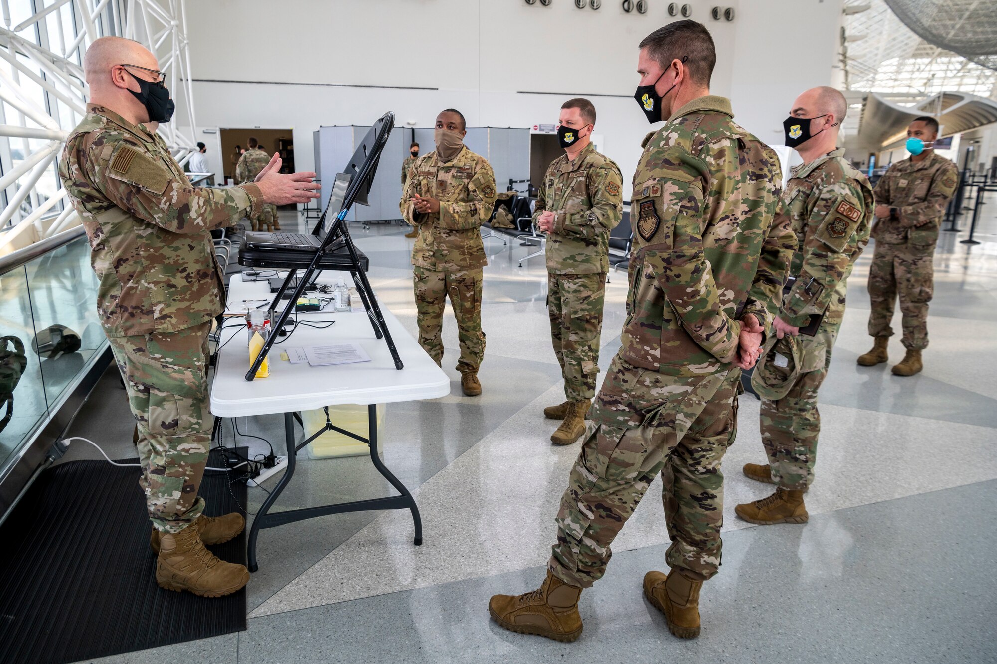 Senior Master Sgt. Harry Kibbe, Patriot Express COVID-19 testing center noncommissioned officer in charge, discusses the COVID-19 testing process at Baltimore/Washington International Thurgood Marshall Airport in Baltimore, Maryland, Jan. 15, 2021. The center provides on-site rapid COVID-19 testing for service members and their families traveling to overseas duty locations. This operation helps ensure U.S. Transportation Command’s continued fulfillment of national security requirements while providing for the health and safety of service members, families and international partners. (U.S. Air Force photo by Senior Airman Christopher Quail)