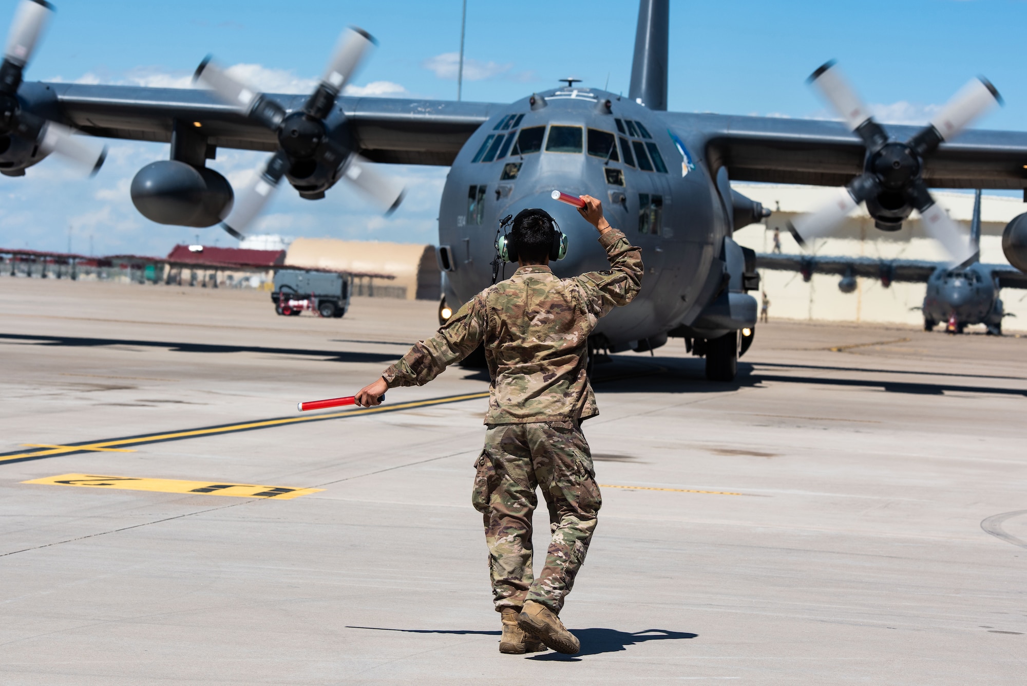 An Airman marshals in a plane to it's resting spot on the flight line