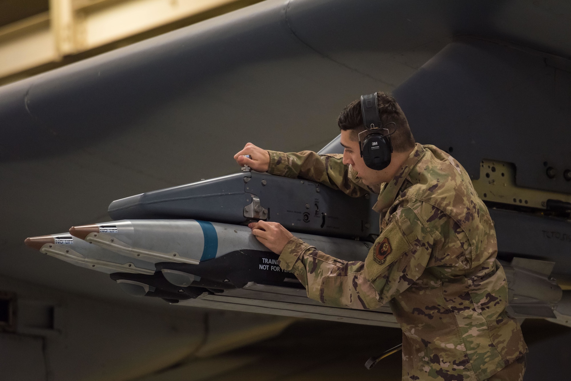 An Airman loads a bomb to a plane during a load competition