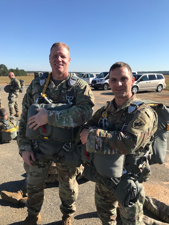 United States Army Civil Affairs and Psychological Operations Command (Airborne) Unit Ministry Team and Strong Bonds Program administrators, Deputy Command Chaplain Joshua A. Cox (left), and Master Religious Affairs Noncommissioned officer, Master Sgt. Fred J. Cohen, don parachutes in preparation for an Airborne operation from a CASA-212 aircraft at Fort Bragg, North Carolina, November 2, 2019.