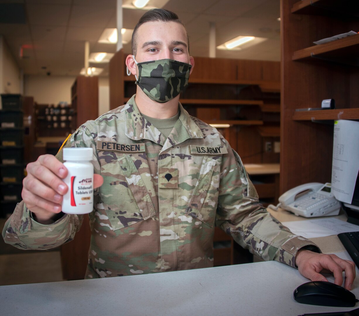 Army Spc. John Petersen, pharmacy technician, hands a prescription to a beneficiary at the Community Pharmacy in the Exchange at Joint Base San Antonio-Fort Sam Houston, Feb. 1. On average, new prescriptions take about 30 minutes to fill. For prescription refills customers generally wait about 2 minutes for pick up.