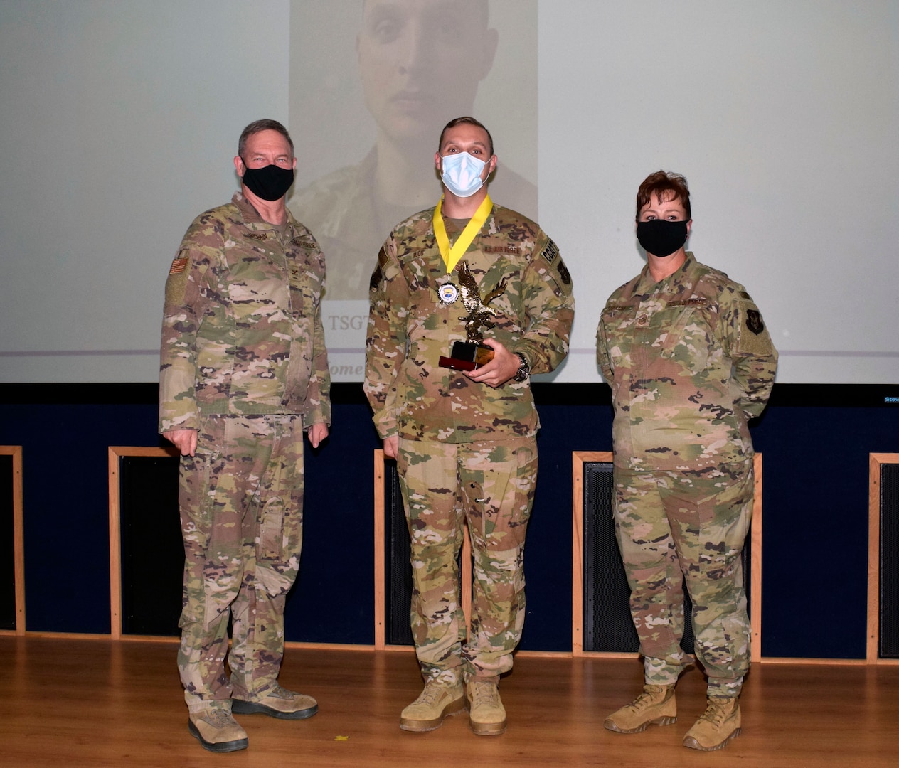 Col. Terry W. McClain, 433rd Airlift Wing commander, and Chief Master Sgt. Shana C. Cullum, 433rd AW command chief, stand to the sides of noncommissioned officer category winner, Tech. Sgt. David M. Rudd, 433rd Medical Squadron, at the wing’s annual award recognition ceremony Jan. 30, 2021 at Joint Base San Antonio-Lackland, Texas. (U.S. Air Force photo by Airman 1st Class Brittany K. Wich)