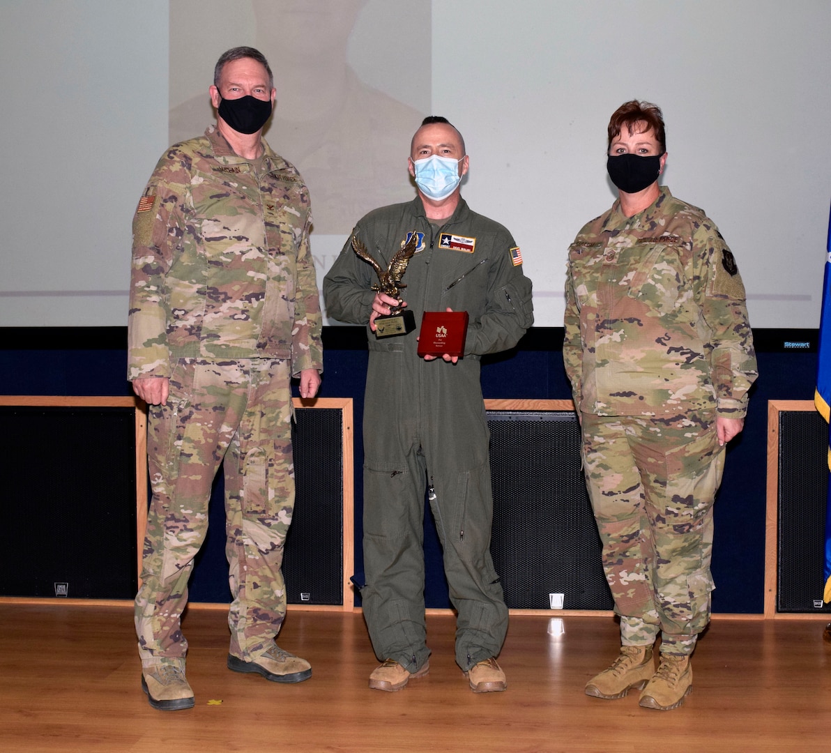 Chief Master Sgt. David J Walsh, 433rd Operations Group (center), accepts the senior noncommissioned officer category award from Col. Terry W. McClain, 433rd Airlift Wing commander, and Chief Master Sgt. Shana C. Cullum, 433rd AW command chief, on behalf of the winner, Master Sgt. Jason Henry, 733rd Training Squadron, during the wing’s annual award recognition ceremony Jan. 30, 2021 at Joint Base San Antonio-Lackland, Texas. Henry was unable to attend the ceremony. (U.S. Air Force photo by Airman 1st Class Brittany K. Wich)