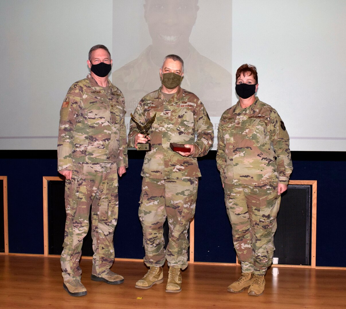 Col. Wayne M. Williams, 433rd Mission Support Group commander (center), accepts the field grade officer category award from Col. Terry W. McClain, 433rd Airlift Wing commander, and Chief Master Sgt. Shana C. Cullum, 433rd AW command chief, on behalf of the winner, Maj. Teanglia A. Moore, 74th Aerial Port Squadron, during the wing’s annual award recognition ceremony Jan. 30, 2021 at Joint Base San Antonio-Lackland, Texas. Moore was unable to attend the ceremony. (U.S. Air Force photo by Airman 1st Class Brittany K. Wich)