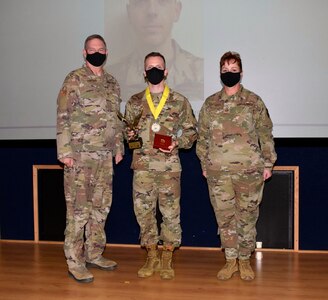 Col. Terry W. McClain, 433rd Airlift Wing commander, and Chief Master Sgt. Shana C. Cullum, 433rd AW command chief, stand to the sides of flight commander category winner, Maj. Luke L. Williams, 74th Aerial Port Squadron, at the wing’s annual award recognition ceremony Jan. 30, 2021 at Joint Base San Antonio-Lackland, Texas. (U.S. Air Force photo by Airman 1st Class Brittany K. Wich)