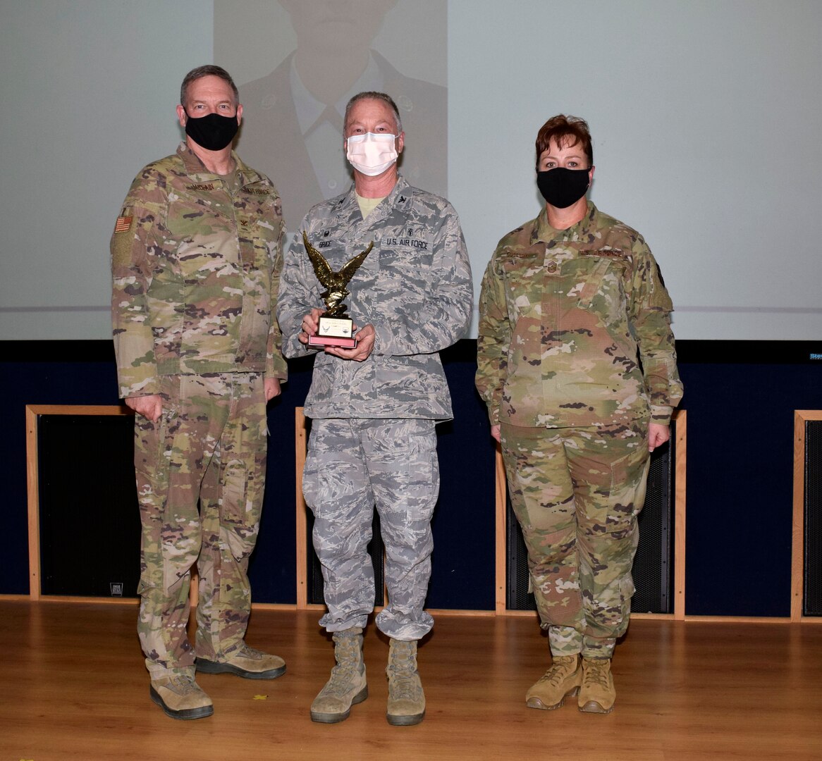 Col. Michael C. Brice, 433rd Medical Group commander (center), accepts the honor guard member category award from Col. Terry W. McClain, 433rd Airlift Wing commander, and Chief Master Sgt. Shana C. Cullum, 433rd AW command chief, on behalf of the winner, Master Sgt. Julie Fuleky, 433rd MDG, during the wing’s annual award recognition ceremony Jan. 30, 2021 at Joint Base San Antonio-Lackland, Texas. Fuleky was unable to attend the ceremony. (U.S. Air Force photo by Airman 1st Class Brittany K. Wich)