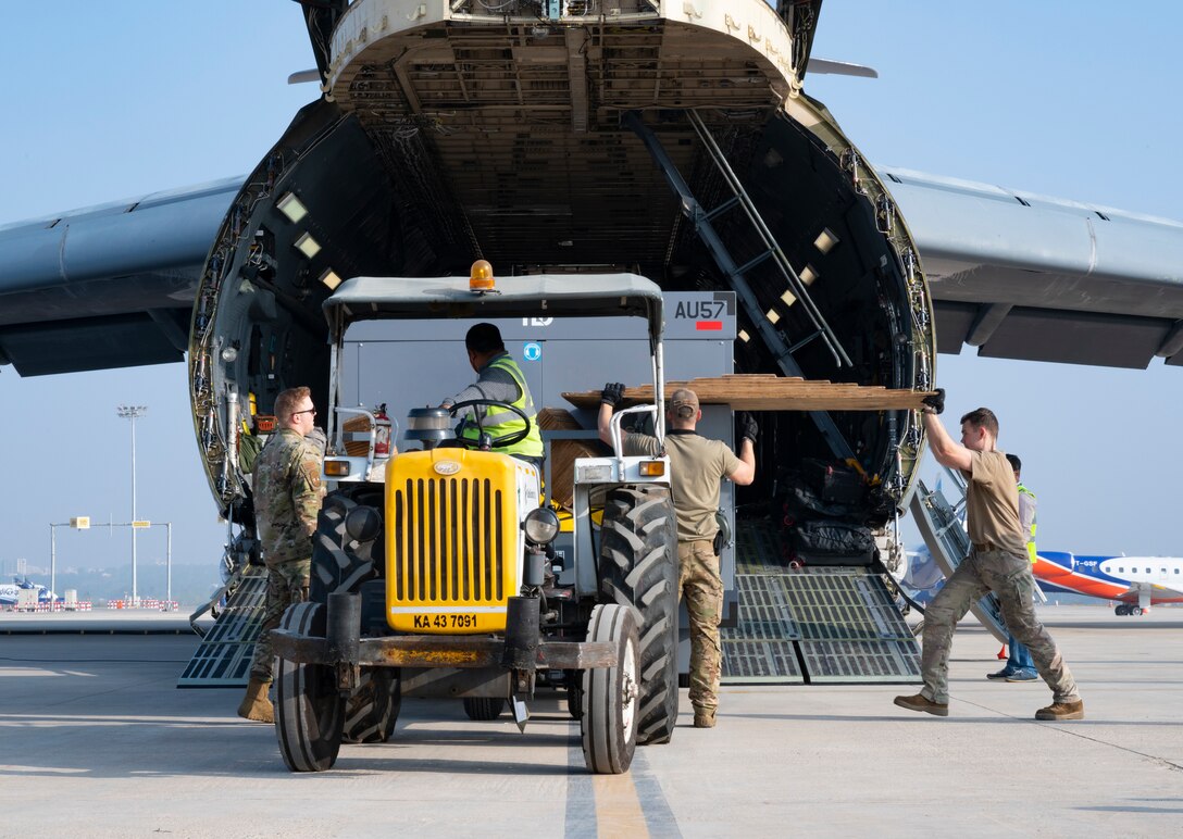 34th Expeditionary Bomb Squadron Airmen from Ellsworth Air Force Base, S.D., work alongside Indian airfield operations specialists to unload B-1B Lancer maintenance equipment from a C-5M Super Galaxy at Kempegowda International Airport in Bengaluru, India, Feb. 1, 2021. The 34th EBS is in India to support the B-1’s participation in Aero India 2021. Aero India provides the opportunity to build a stronger relationship between the United States and India, as well as with the international community. (U.S. Air Force photo by Senior Airman Christina Bennett)