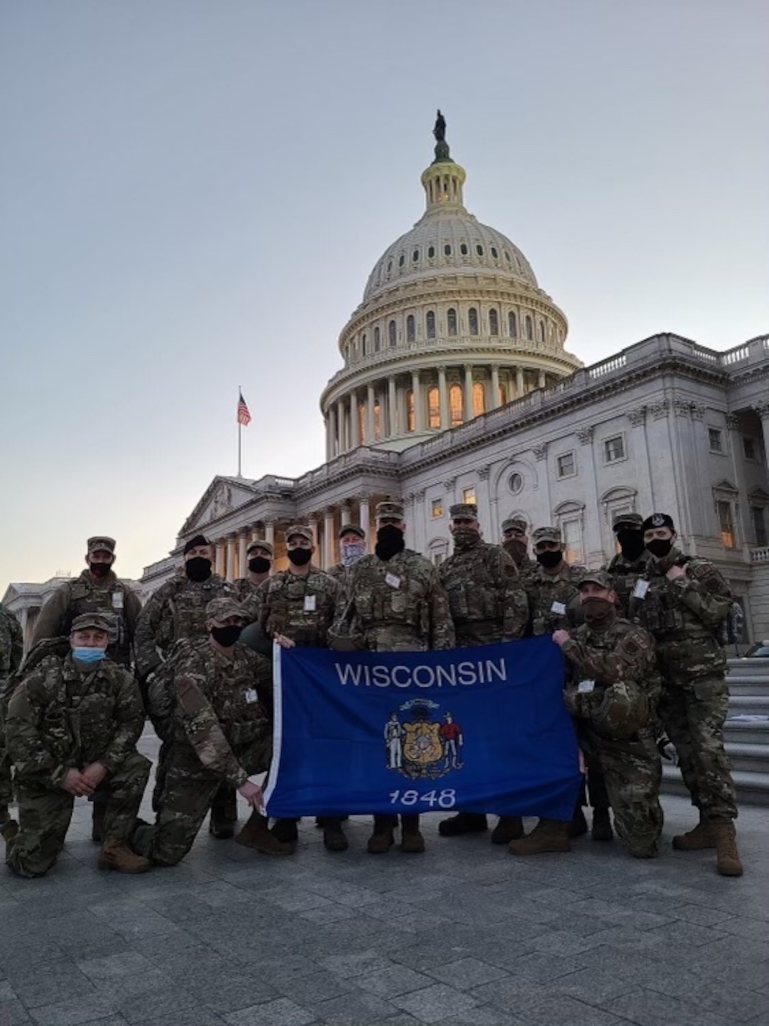 Members from the 128th Air Refueling Wing stand with the Wisconsin state flag on the steps of the U.S. Capitol building Jan. 20, 2021. In the days leading up to the 59th presidential inauguration more than 125 Wisconsin Airmen from the 128th Air Refueling Wing, 115th Fighter Wing and Volk Field Combat Readiness Training Center mobilized to Washington D.C. to assist with security efforts for the event. (Courtesy photo)