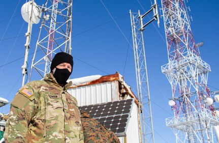 Chief Warrant Officer 2 John Finken, a contracting officer representative with Regional Command-East, Kosovo Force, inspects contractors performing maintenance during a radio systems inspection at Mount Golesh in Kosovo Jan. 28, 2021. During the inspection, the contractors check voltage on batteries, test transmitting power and perform other maintenance checks to ensure radio communication can be maintained.