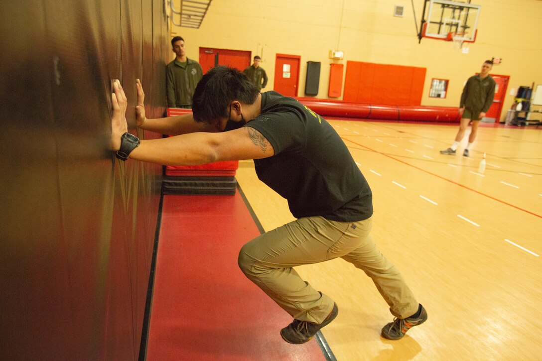 Mr. Allen Sese, the High Intensity Tactical Training (HITT) Coordinator for U.S. Marine Corps Forces Command, Headquarters and Service Battalion, demonstrates a workout during a HITT course in the Hopkins Gymnasium on Camp Elmore, Norfolk, Virginia, January 27, 2021. HITT is a comprehensive strength and conditioning program that focuses on maintaining and improving physical resiliency and combat readiness. The Marines that progressed through the course will be a knowledgeable resource for physical training (PT) and will be able to conduct PT properly within their respective units. (U.S. Marine Corps Photo by Lance Cpl. Jack Chen/released)