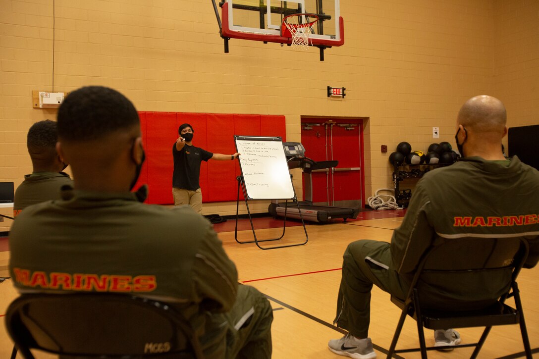 Mr. Allen Sese, the High Intensity Tactical Training (HITT) Coordinator for U.S. Marine Corps Forces Command, Headquarters and Service Battalion, explains to the students the plane of motion for a workout during a HITT course in the Hopkins Gymnasium on Camp Elmore, Norfolk, Virginia, January 26, 2021. HITT is a comprehensive strength and conditioning program that focuses on maintaining and improving physical resiliency and combat readiness. The Marines that progressed through the course will be a knowledgeable resource for physical training (PT) and will be able to conduct PT properly within their respective units. (U.S. Marine Corps Photo by Lance Cpl. Jack Chen/released)