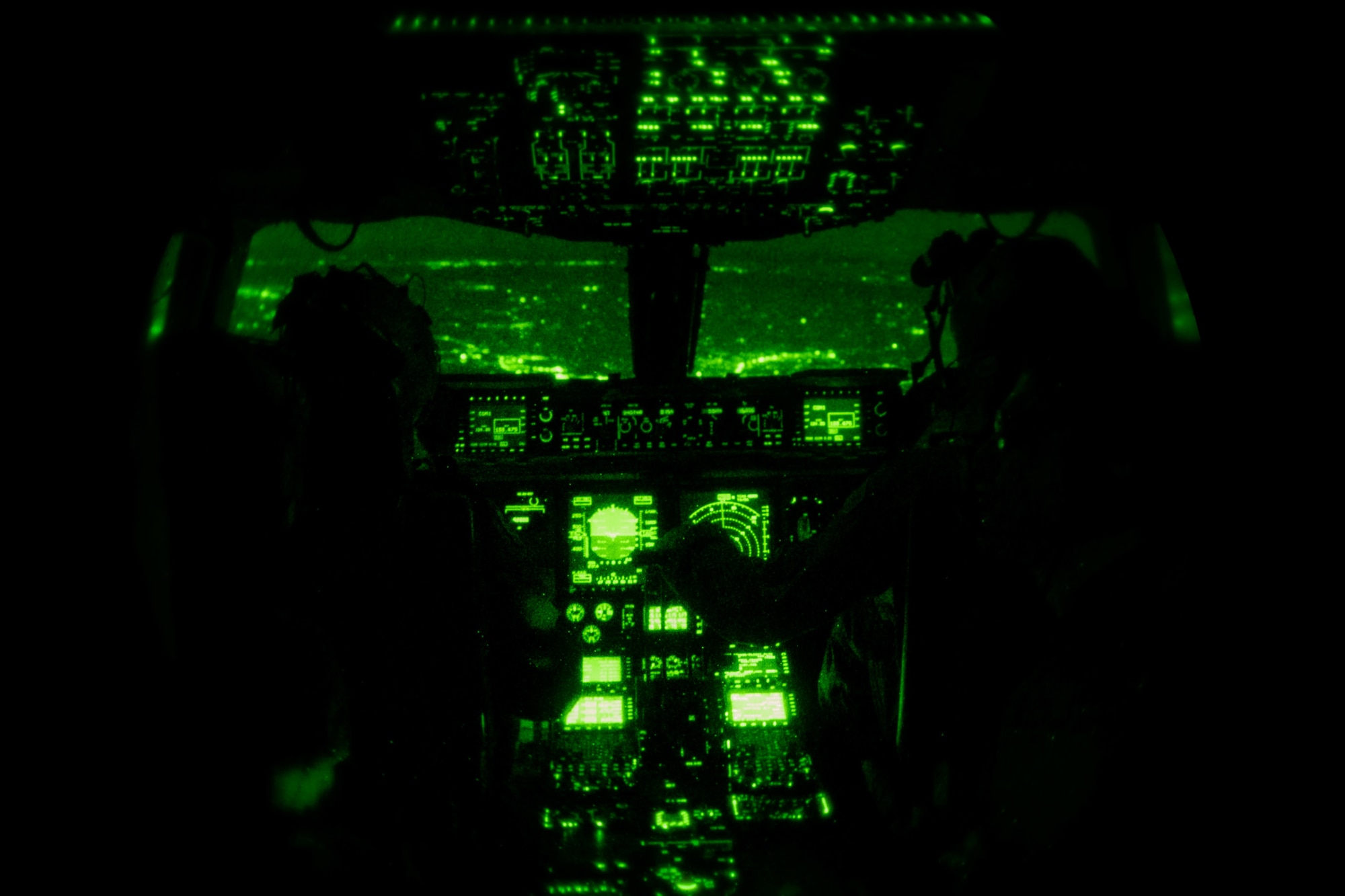 1st Lt. Zachary Pruitt, 3rd Airlift Squadron pilot, and Capt. Corey Landis, 3rd AS instructor pilot, fly a C-17 Globemaster III over Pennsylvania, while wearing night vision goggles, Jan. 28, 2021. In combat, flying at night without artificial light minimizes visibility of the aircraft and reduces threat from potential enemies. The 3rd AS routinely trains to support global engagement through direct delivery of time-critical theater deployment assets and ensure aircrew operational readiness. (U.S. Air Force photo by Airman 1st Class Faith Schaefer)