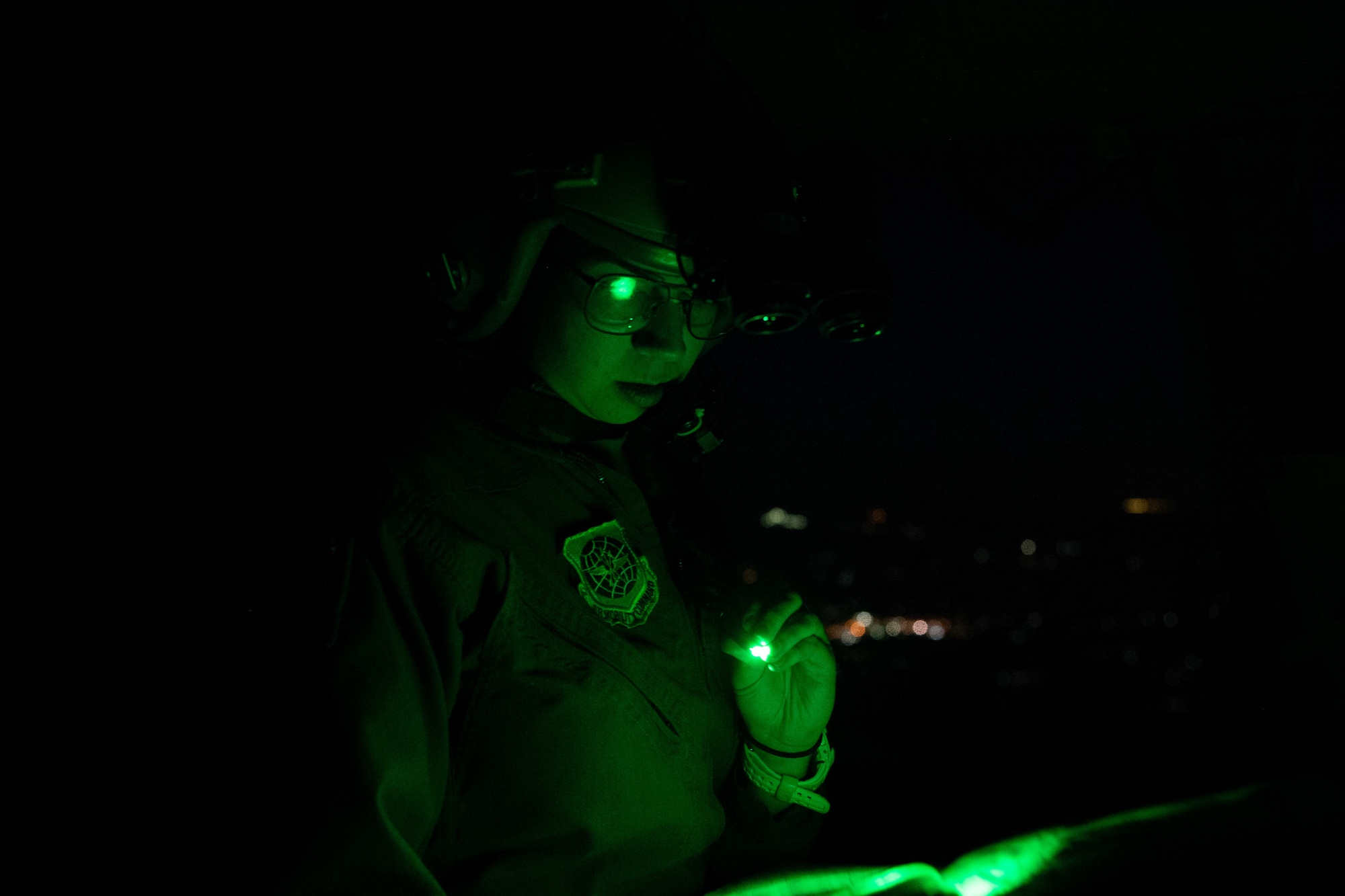 Capt. Sarah Aravich, 3rd Airlift Squadron pilot, reads a map during a training sortie on a C-17 Globemaster III over Pennsylvania, Jan. 28, 2021. In combat, flying at night without artificial light minimizes visibility of the aircraft and reduces threat from potential enemies. The 3rd AS routinely trains to support global engagement through direct delivery of time-critical theater deployment assets and ensure aircrew operational readiness. (U.S. Air Force photo by Airman 1st Class Faith Schaefer)