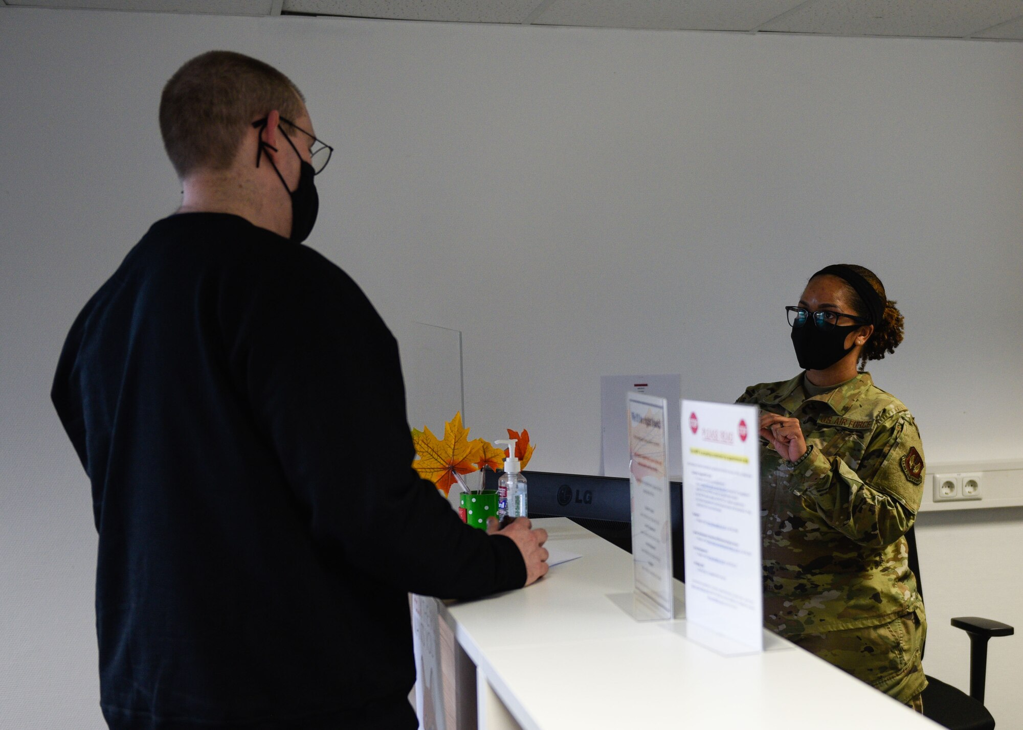 U.S. Air Force Tech Sgt. Michelle Paul, 52nd Military Personnel Flight NCOIC of customer support (right), assists a customer at Spangdahlem Air Base, Germany, Feb. 3, 2021. Paul said despite the pandemic, her section still works after business hours to ensure every customer is taken care of.  (U.S. Air Force photo by Senior Airman Melody W. Howley)