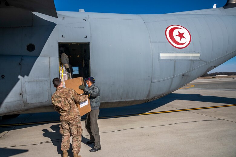 Staff Sgt. Deric Sexton, 436th Aerial Port Squadron load planner, delivers foreign military sales cargo to a Tunisian air force airman at Dover Air Force Base, Delaware, Jan. 28, 2021. The U.S. and Tunisia have enjoyed strong diplomatic relations for over 200 years, a special bond first enshrined when the two countries signed the Treaty of Peace and Friendship in 1797. Tunisia was among the first to recognize the newly independent U.S. during that time. Due to its strategic geographic location, Dover AFB supports approximately $3.5 billion worth of FMS operations annually. (U.S. Air Force photo by Senior Airman Christopher Quail)
