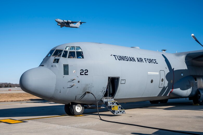 A Dover Air Force Base C-17 Globemaster III flies above a Tunisian air force C-130J Super Hercules during a foreign military sales mission at Dover AFB, Delaware, Jan. 28, 2021. The U.S. was the first major power to recognize Tunisian sovereignty and established relations with Tunisia in 1956 following its independence from France. Since then, Tunisia has become an even more critical partner and a major non-NATO ally, which entails military and economic privileges and is a powerful symbol of the close relationship between the U.S. and Tunisia. Due to its strategic geographic location, Dover AFB supports approximately $3.5 billion worth of FMS operations annually. (U.S. Air Force photo by Senior Airman Christopher Quail)
