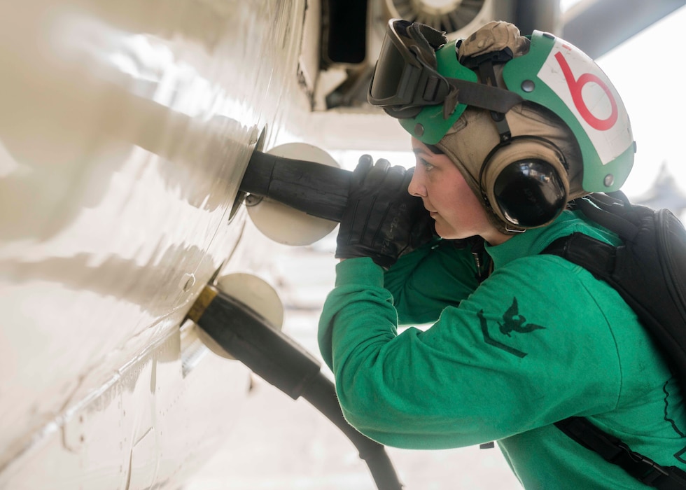 Aviation Electronics Technician 3rd Class Koryna Moore connects an electrical plug to an E-2D Hawkeye attached to the �Bluetails� of Carrier Airborne Early Warning Squadron (VAW) 121 on the flight deck of the aircraft carrier USS Abraham Lincoln (CVN 72).