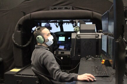 Kevin Graham, an Instructor Operator of the BAT system at Fort Knox, Kentucky, monitors Chief Warrant Officer 2 Paul Schroaders' progress as he presents the helicopter pilot with various scenarios inside the simulator. Fort Knox is the first installation to receive the system configured to train for both the UH-60M and UH-60L.