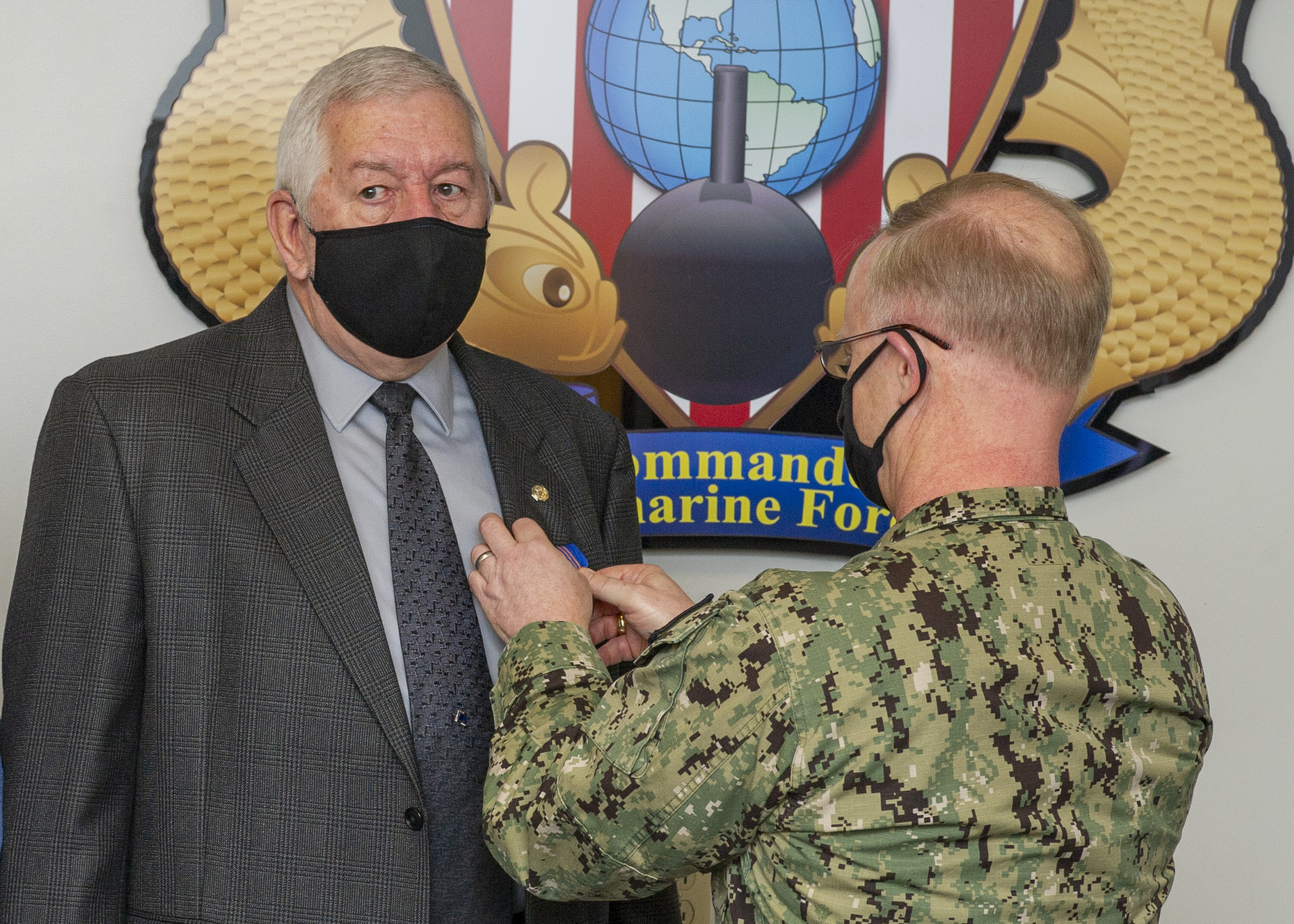 Vice Adm. Daryl Caudle, right, commander, Submarine Forces, pins the civilian of the year award on Robert Tayman