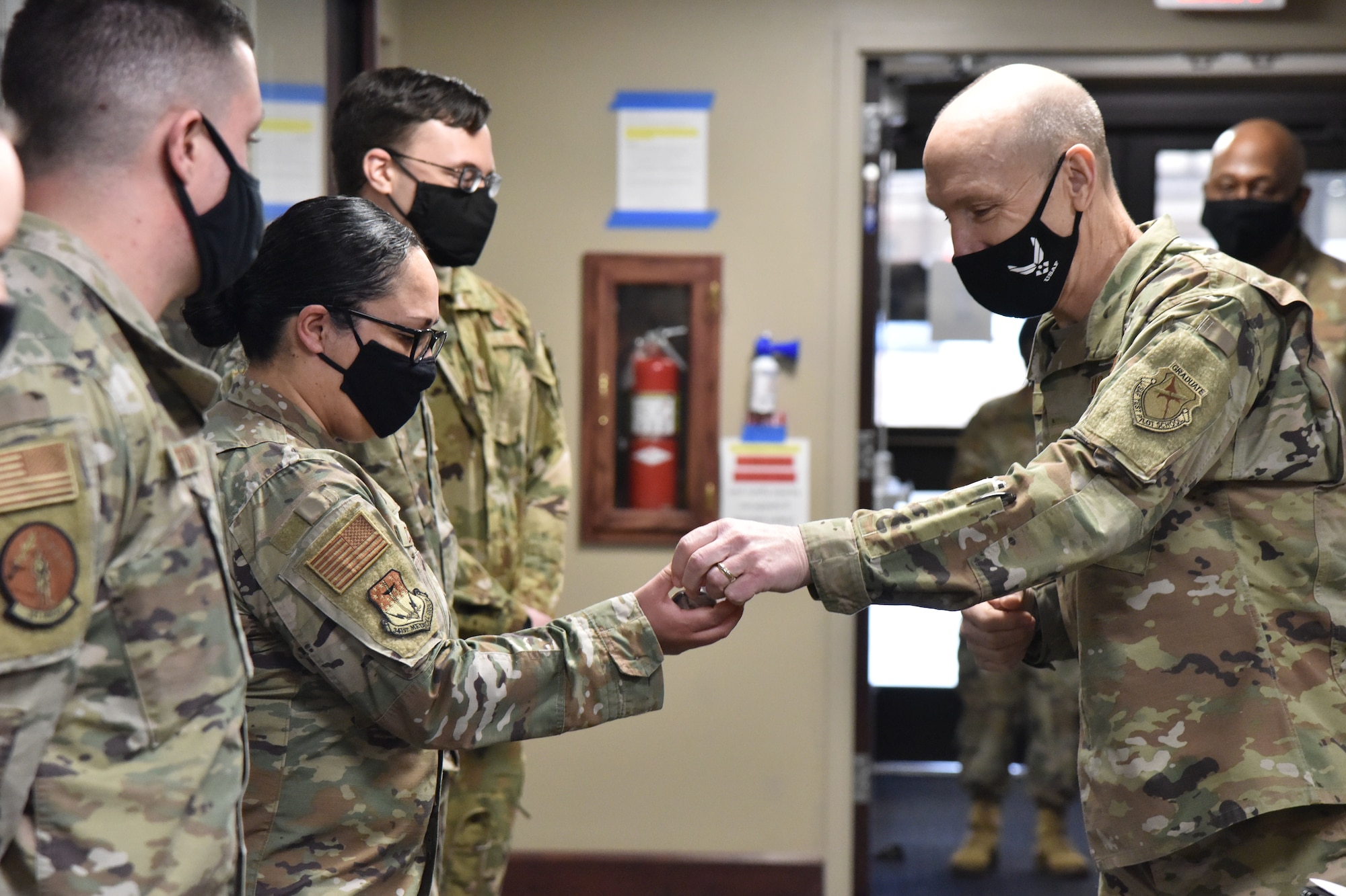 Air Force Vice Chief of Staff Gen. David Allvin presents a coin for exceptional performance to Tech Sgt. Mayra Corona, 341st Medical Group Military Health System Genesis project coordinator, Jan. 29, 2021, during a trip to Malmstrom Air Force Base, Mont. (U.S. Air Force photo by Senior Airman Daniel Brosam)
