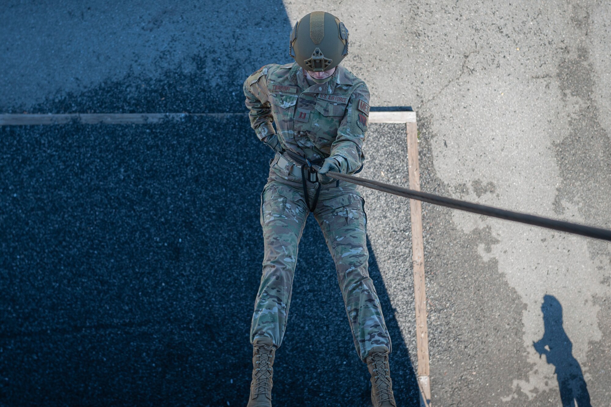 Photo of an Airman rappelling from a tower