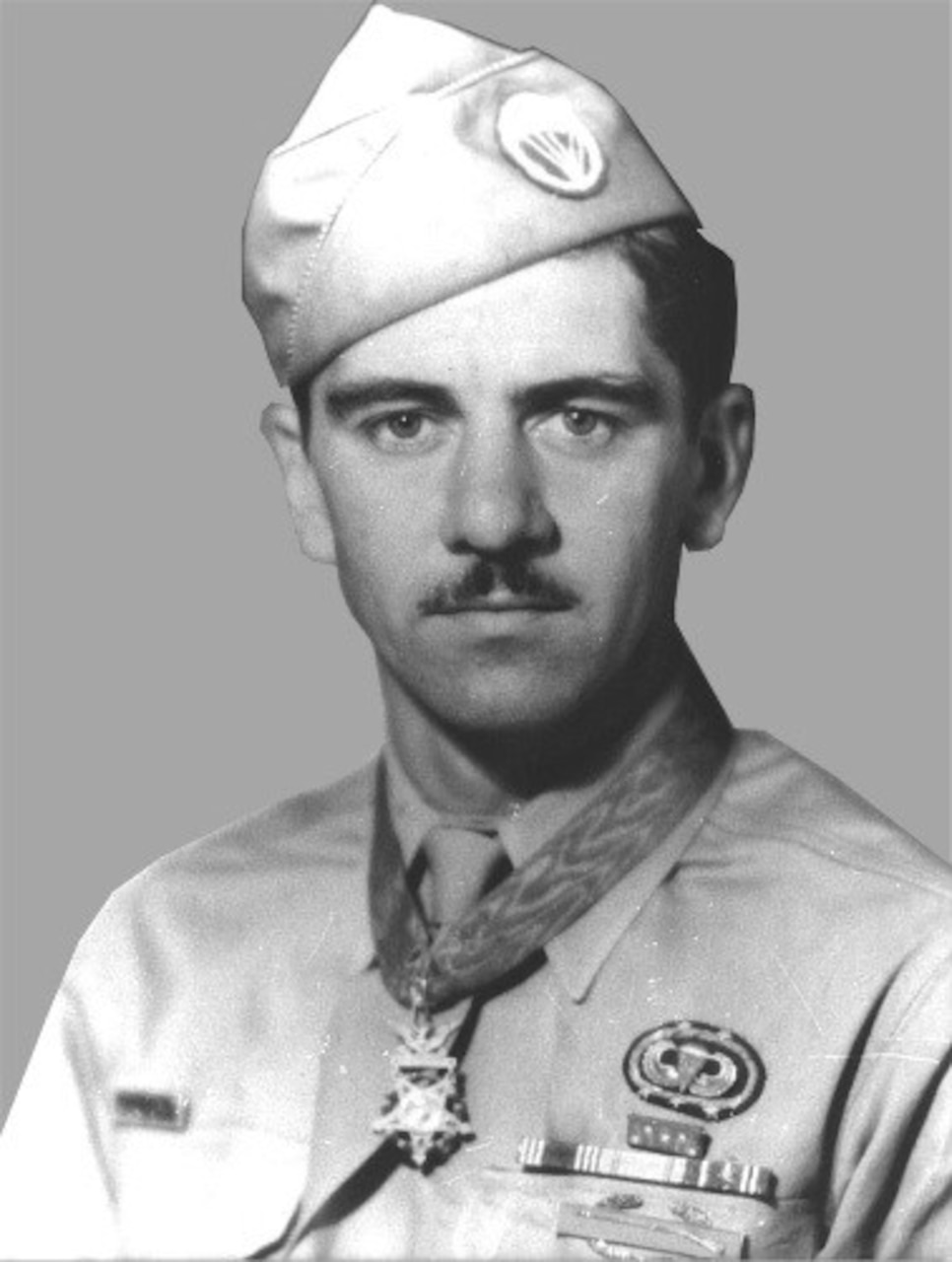 A man in uniform wears a medal around his neck.