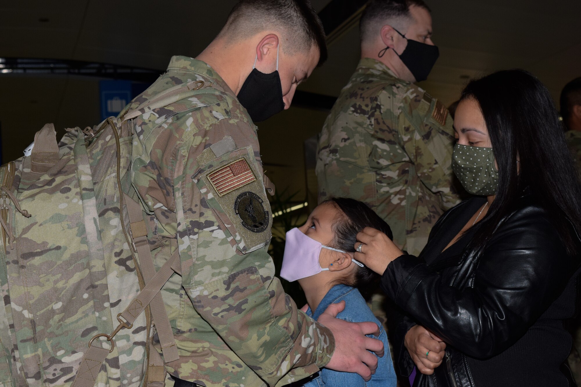 Staff Sgt. Justin Stevenson, 433rd Security Forces Squadron, reconciles with his family at the airport in San Antonio Jan. 31, 2021. Stevenson was one of the defenders returning home from a six-month deployment to aid in on-going operations in Southwest Asia. (U.S. Air Force photo by Airman 1st Class Brittany Wich).