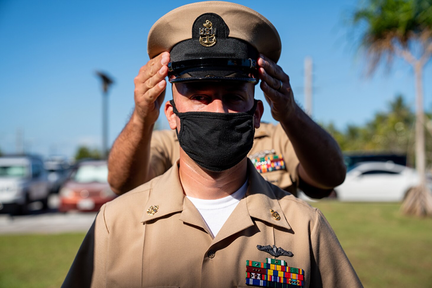 SANTA RITA, Guam (Jan. 29, 2021) Chief Hospital Corpsman Nicholas Manjarrez, assigned to Commander, Submarine Squadron 15, from Normal, Illinois, receives his combination cover from Senior Chief Electricians Mate (Nuclear) Maren Tollefson, from Stanley, North Dakota, assigned to CSS-15, during a chief pinning ceremony at Konetzni Hall. CSS-15 is responsible for providing training, material, and personnel readiness support to multiple Los Angeles-class fast-attack submarine commands located at Polaris Point, Naval Base Guam.