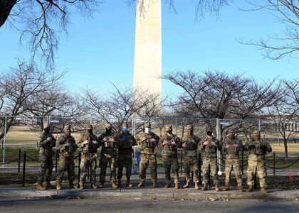 Airmen of the 157th Security Forces Squadron, NHANG, pose before the Washington Monument at the National Mall on Jan. 20, 2021, in Washington, D.C.