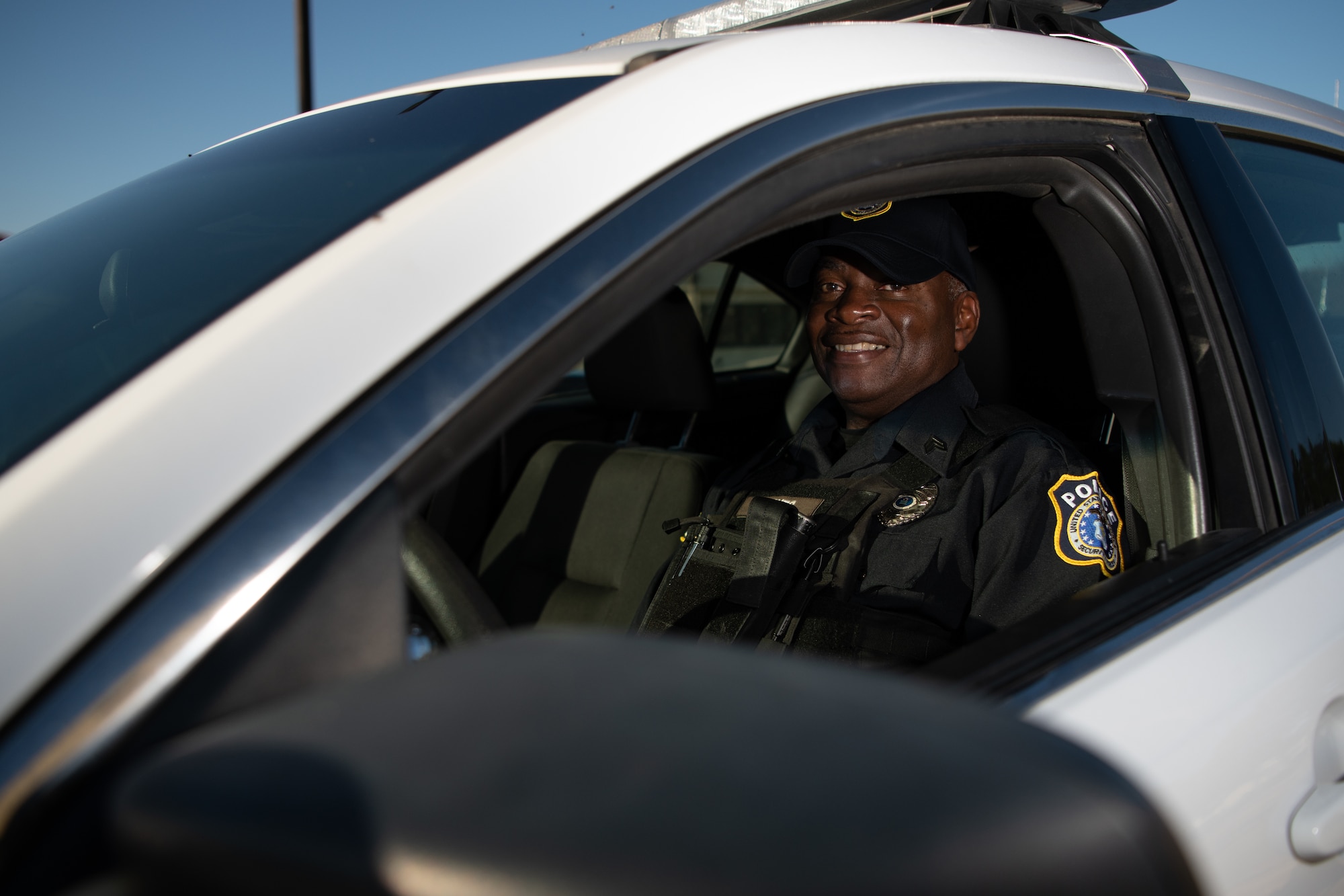 Morris Barnes, a flight sergeant with the 42nd Security Forces Squadron, poses for a photo inside a patrol car Dec. 12, 2021, on Maxwell Air Force Base, Alabama. Barnes served in the Air Force for 26 years before he began working as a civilian defender on Maxwell.