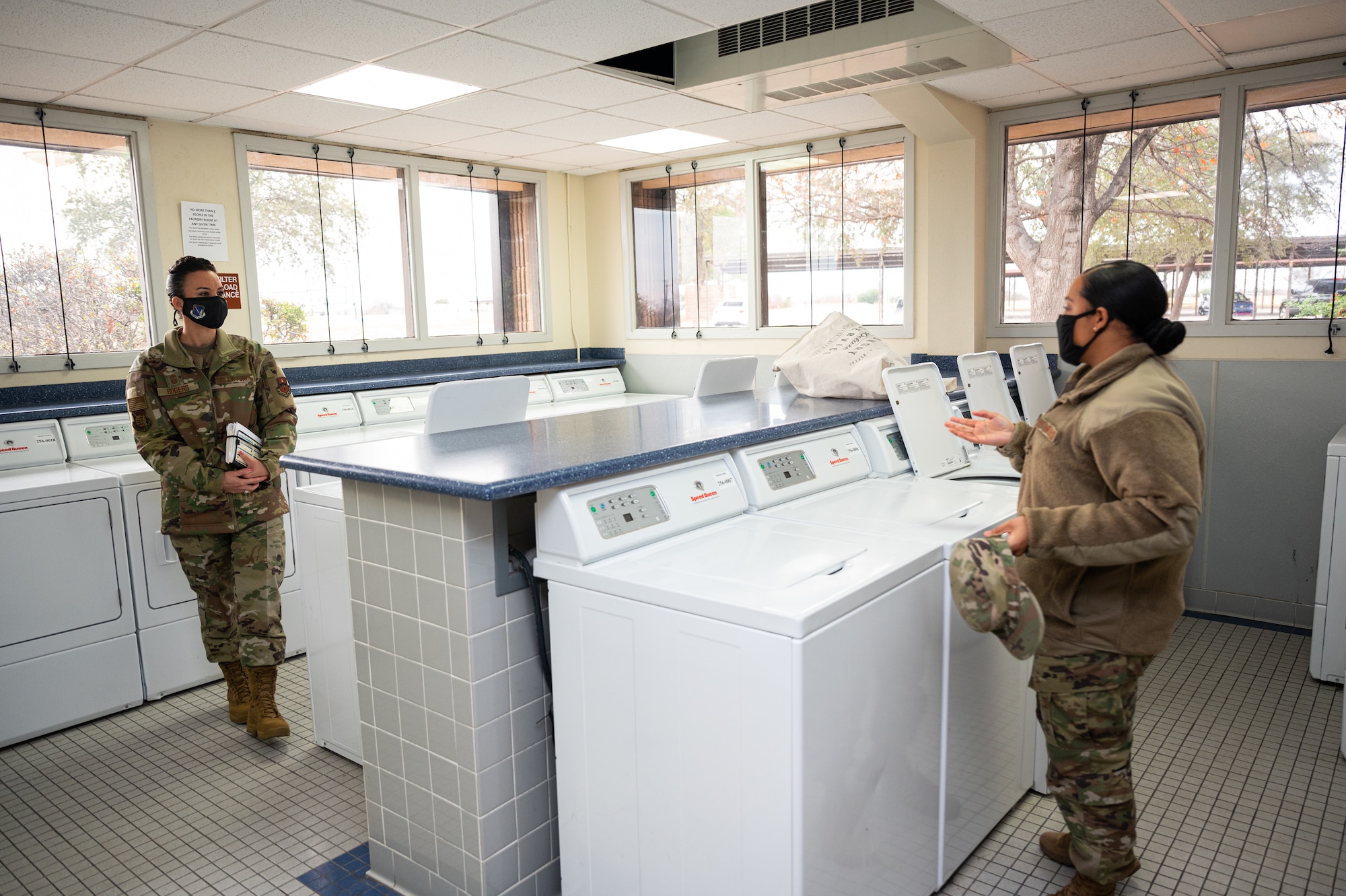Chief Master Sgt. Kristina L. Rogers, 19th Air Force command chief master sergeant, discusses the enlisted dorm laundry room with Tech Sgt. Patsy Robles-Pena, enlisted dorm leader, at Laughlin Air Force Base, Texas, on Jan. 21, 2021. Robles-Pena and Rogers spent time looking at several dorm features including dorms, kitchen and other community areas. (U.S. Air Force photo by Senior Airman Marco A. Gomez)