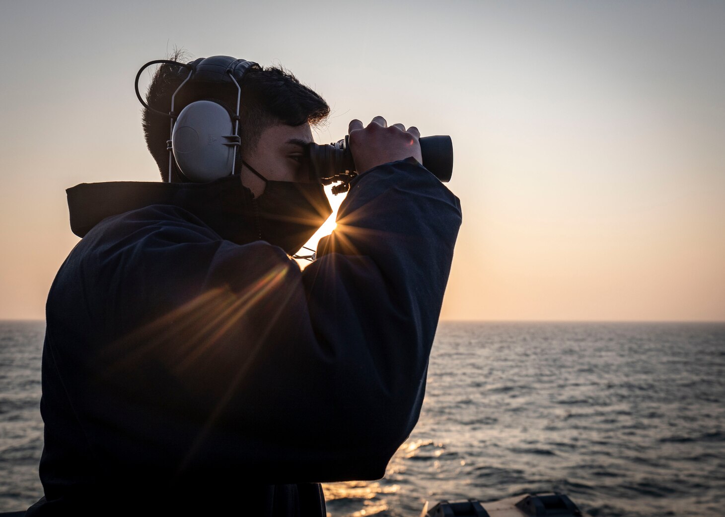 TAIWAN STRAIT - Seaman Frank Medina, from Dallas, Texas, scans the horizon while standing on the bridge wing aboard the Arleigh Burke-class guided-missile destroyer USS John S. McCain (DDG 56) as the ship conducts routine underway operations. McCain is forward-deployed to the U.S. 7th Fleet area of operations in support of security and stability in the Indo-Pacific region.