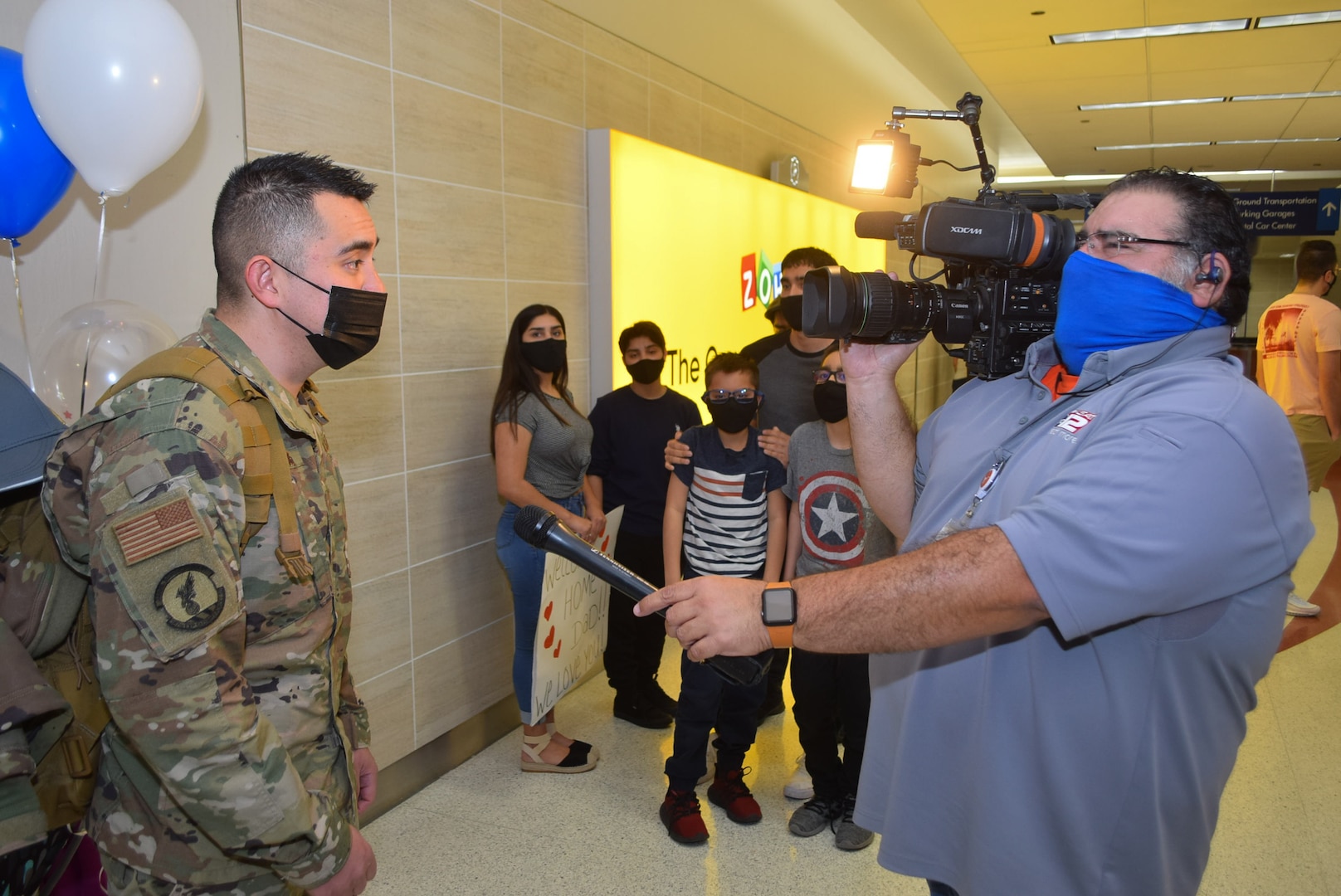 Tech. Sgt. Steven Redgate, 433rd Security Forces Squadron, speaks to a reporter with a local television station, for an on camera interview at the airport in San Antonio Jan. 31, 2021. Redgate was one of the defenders returning home from a six-month deployment to Southwest Asia. (U.S. Air Force photo by Tech. Sgt. Mike Lahrman)