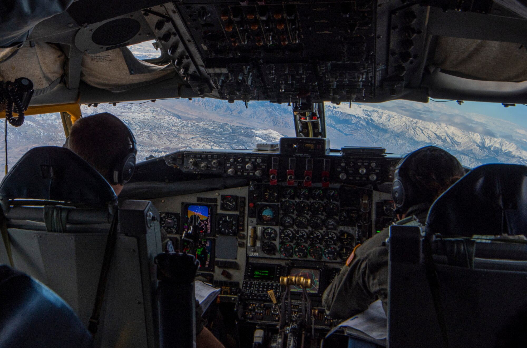 Pilots sit in a KC-135 cockpit.