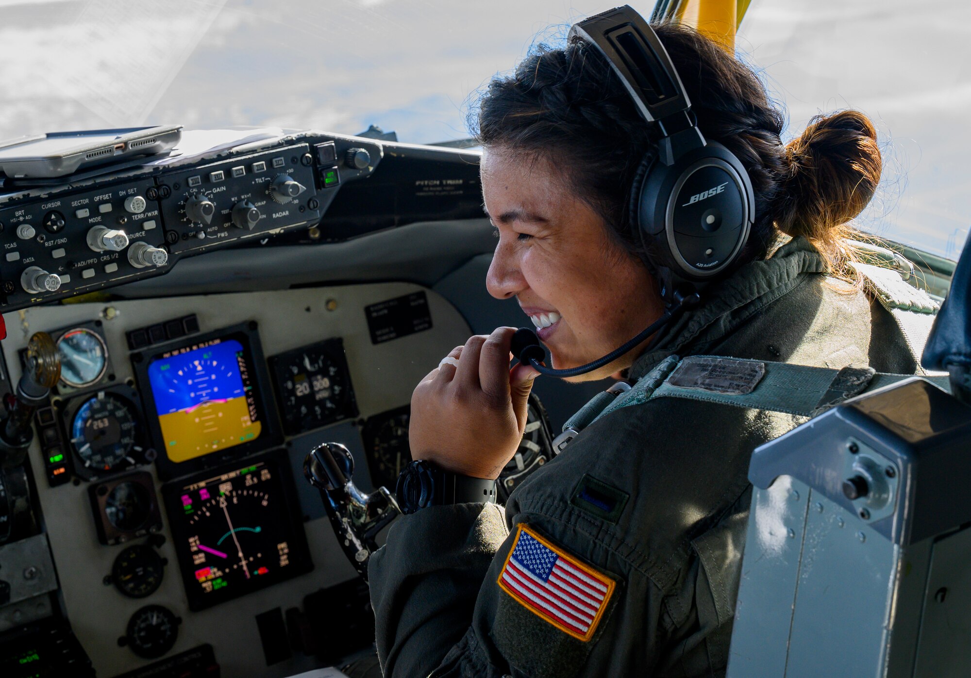 Airman smiles while sitting in a KC-135 aircraft.